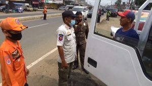 Petugas tengah menegur warga yang tidak pakai masker