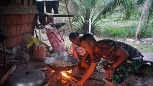 foto personil tmmd112 bantu ibu asuh masak